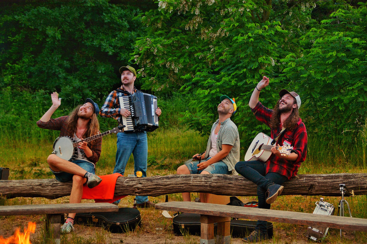 Band spielt bei einem Lagerfeuer als abgerundetes Programm - Teamauszeit in musikalische Atmosphäre fördert Zusammenhalt und Entspannung.