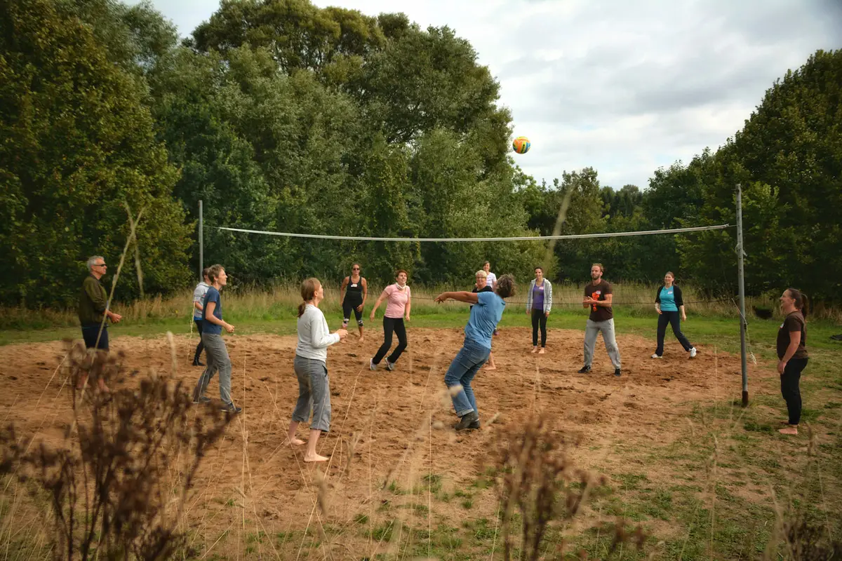 Kolleg:innen spielen Volleyball beim Teamevent während eines Retreats – sportliche Aktivität zur Stärkung der Teambindung