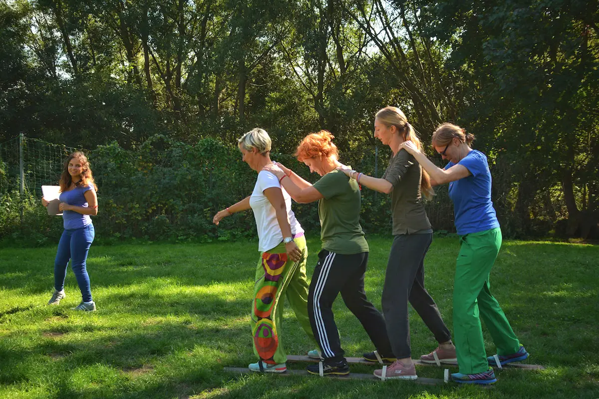 Team auf einem Teamski bei einem Teambuilding-Event – gemeinsame Bewegung fördert Koordination und Zusammenhalt.