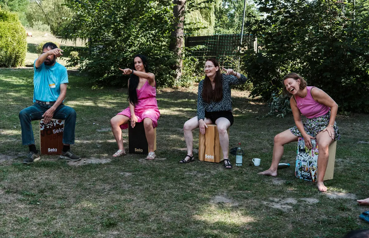 Team trommelt gemeinsam auf Cajons bei einem Musik-Workshop als kreatives Incentive – mitreißender Rhythmus für Motivation und Zusammenhalt.
