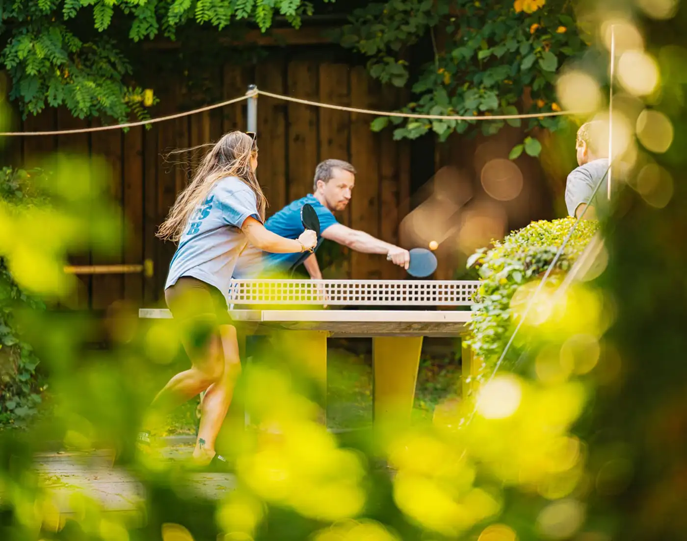 Teilnehmende eines Team-Retreats spielen zur Auflockerung eine Runde Tischtennis.