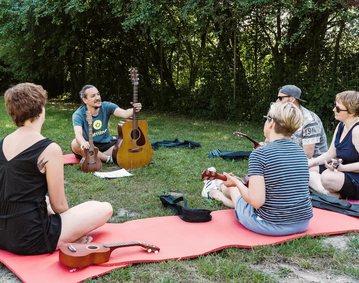 Teilnehmende eines Team-Offsites beim Ukulele-Workshop, spielend auf Ukulelen.